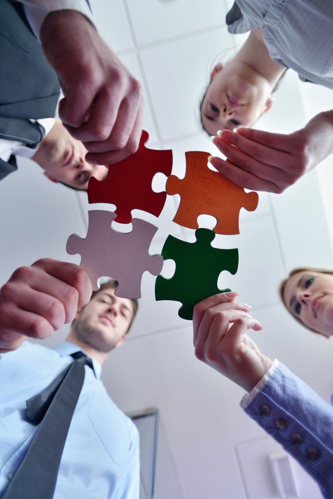 Group of business people assembling jigsaw puzzle and represent team support and help concept Group of business people assembling jigsaw puzzle and represent team support and help concept